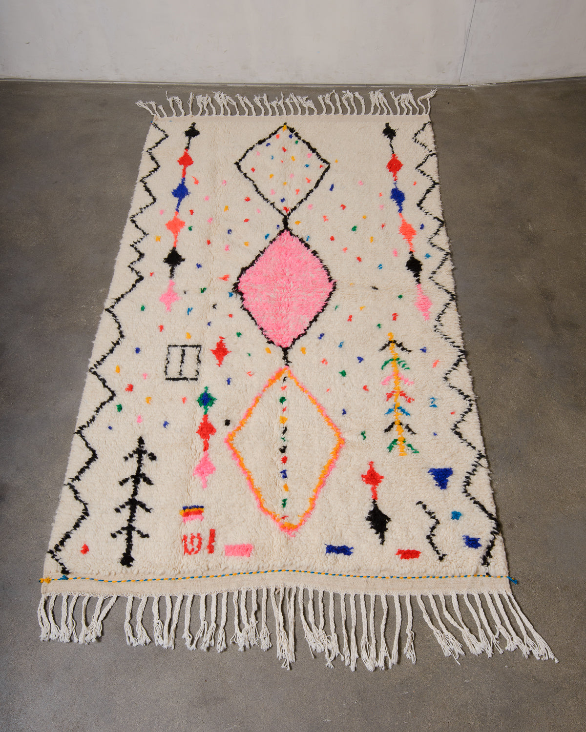 Berberlin Azilal rug made of fluffy wool and cotton, laying flat on a concrete floor.
